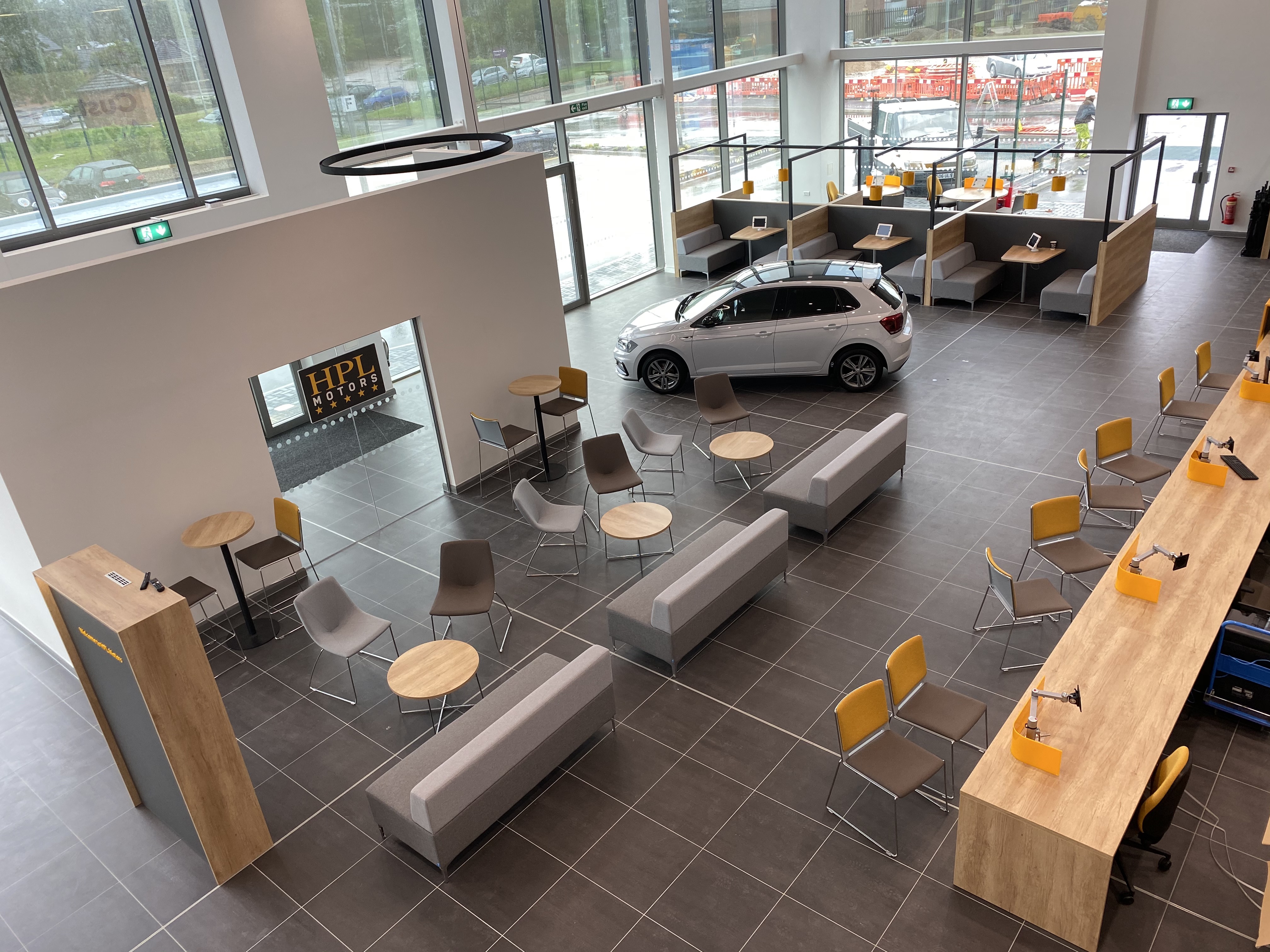 Interior of a HPL Motors Car Showroom with a Car and seating areas surrounding it